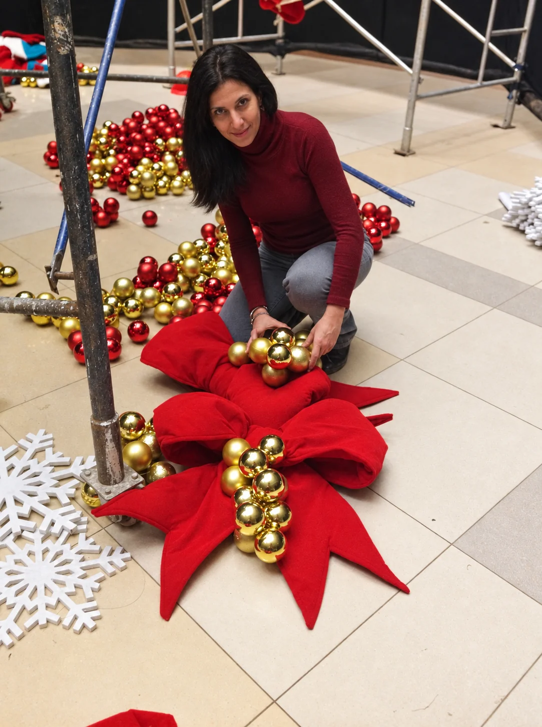Karina Barhumi trabajando de joven en el montaje de una campaña de gran escala, entre adornos rojos y dorados